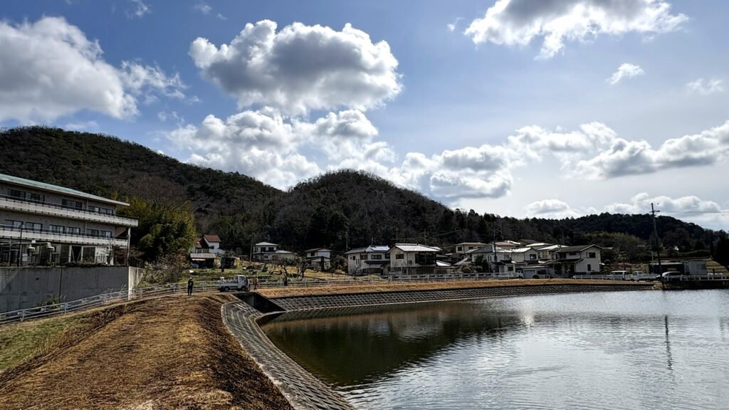 青空の下に広がる西谷のため池と里山の風景