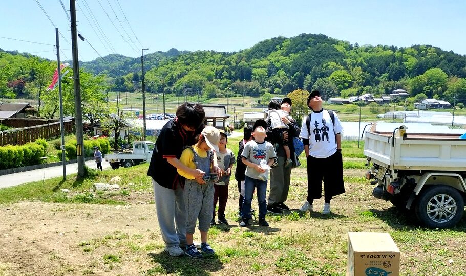西谷の自然の中でドローン操縦体験を楽しむ子どもたち