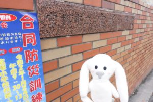 宝塚小学校の校門に合同防災訓練のポスターが貼ってあります。まちキョンも映っています。